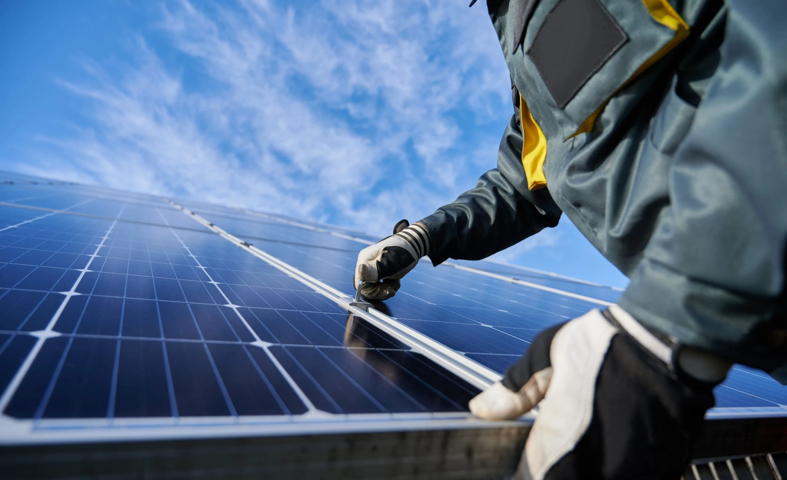 Installateur fixant un panneau solaire sur une toiture professionnelle