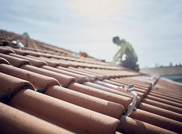 Technicien EV Auvergne travaillant sur une toiture en tuiles