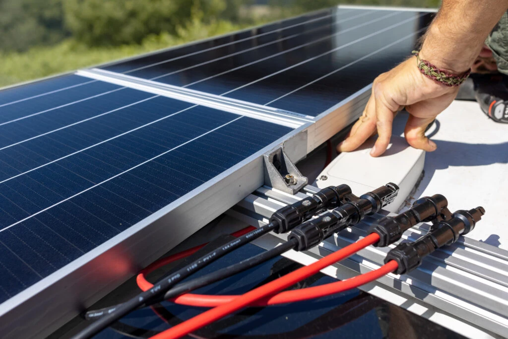 Branchement des connecteurs sous un panneau solaire lors d’une maintenance photovoltaïque