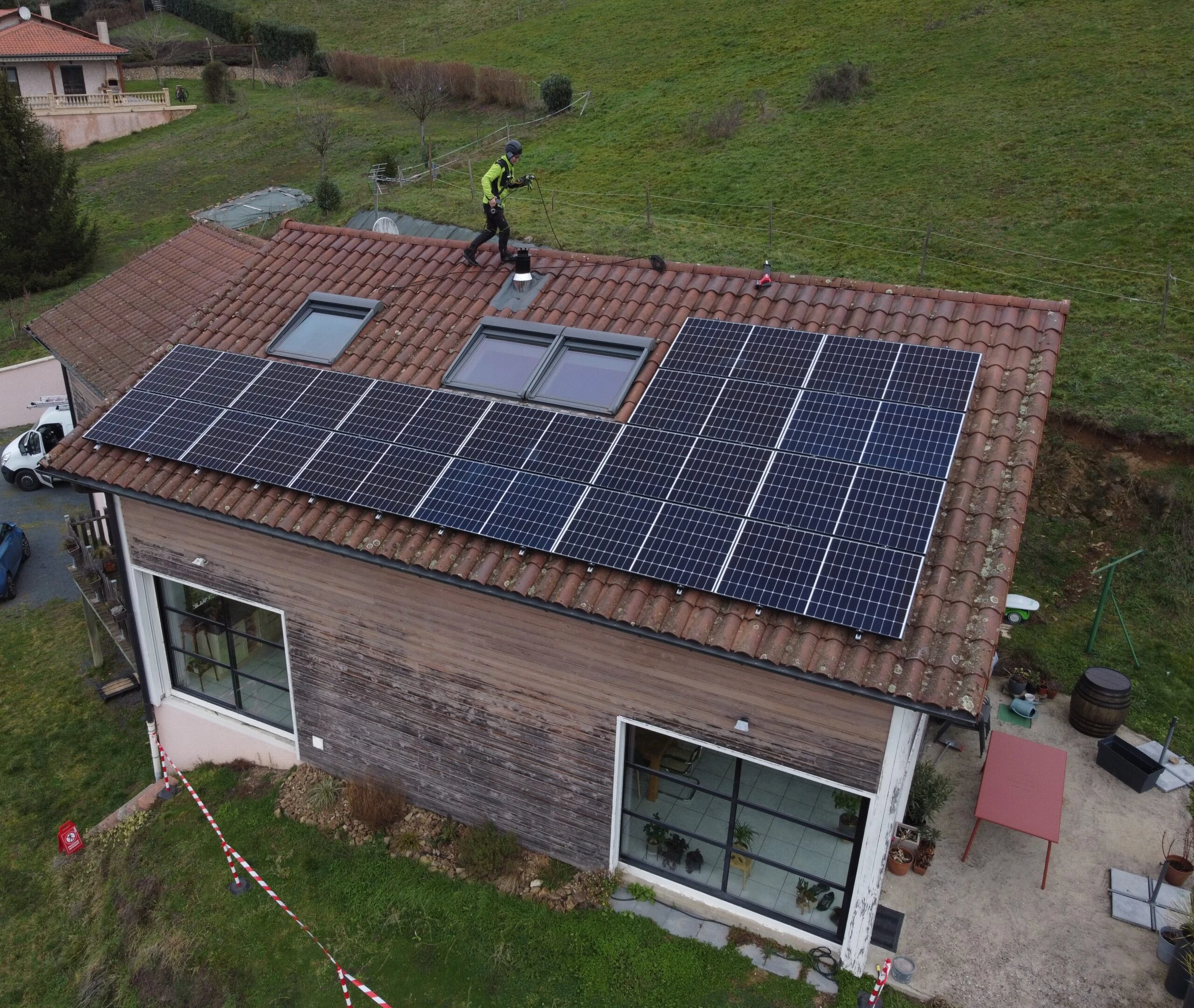 Technicien en intervention de dépannage sur des panneaux solaires, vu du ciel