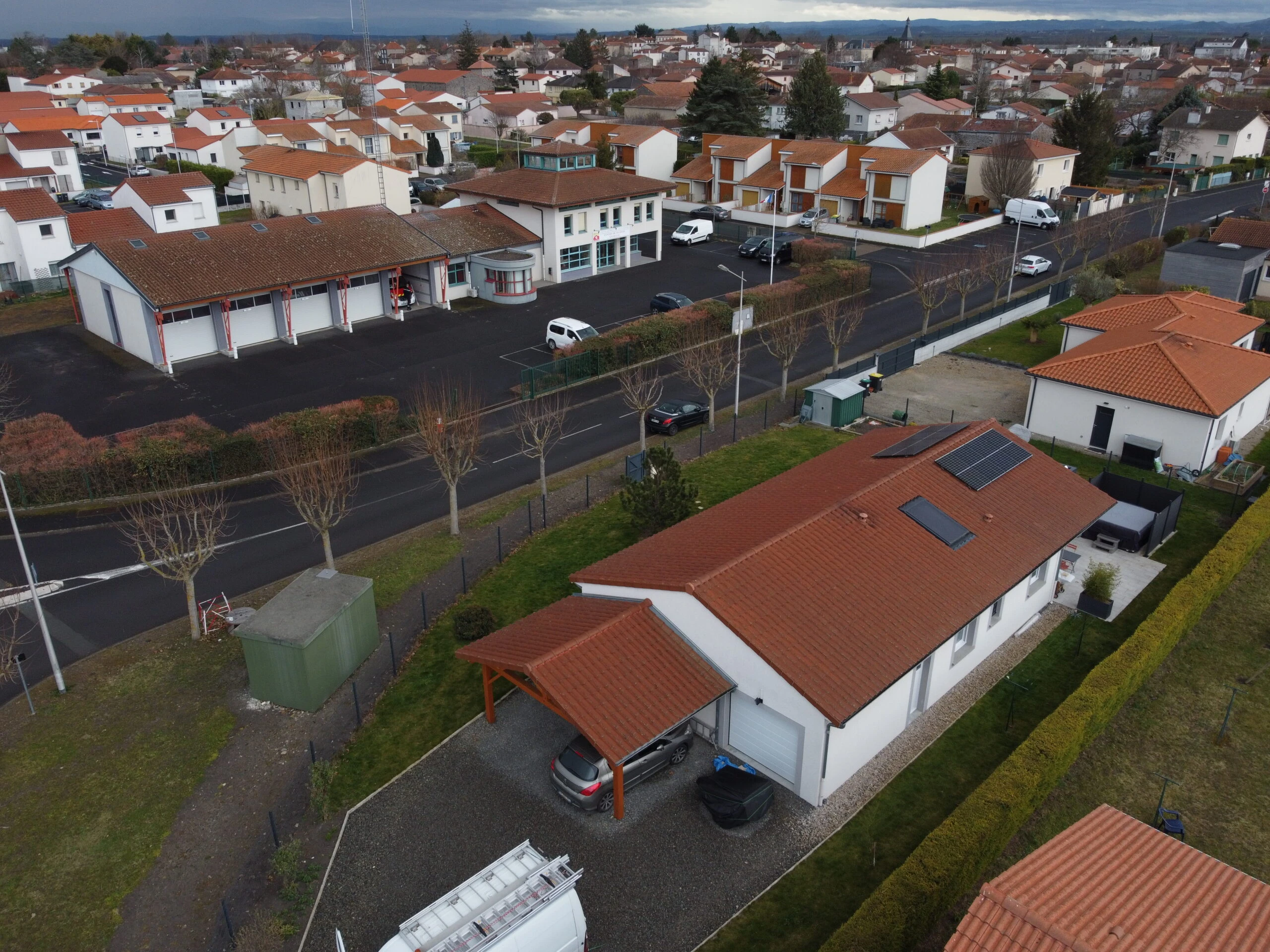 Vue aérienne d’un quartier résidentiel avec une maison équipée de panneaux solaires
