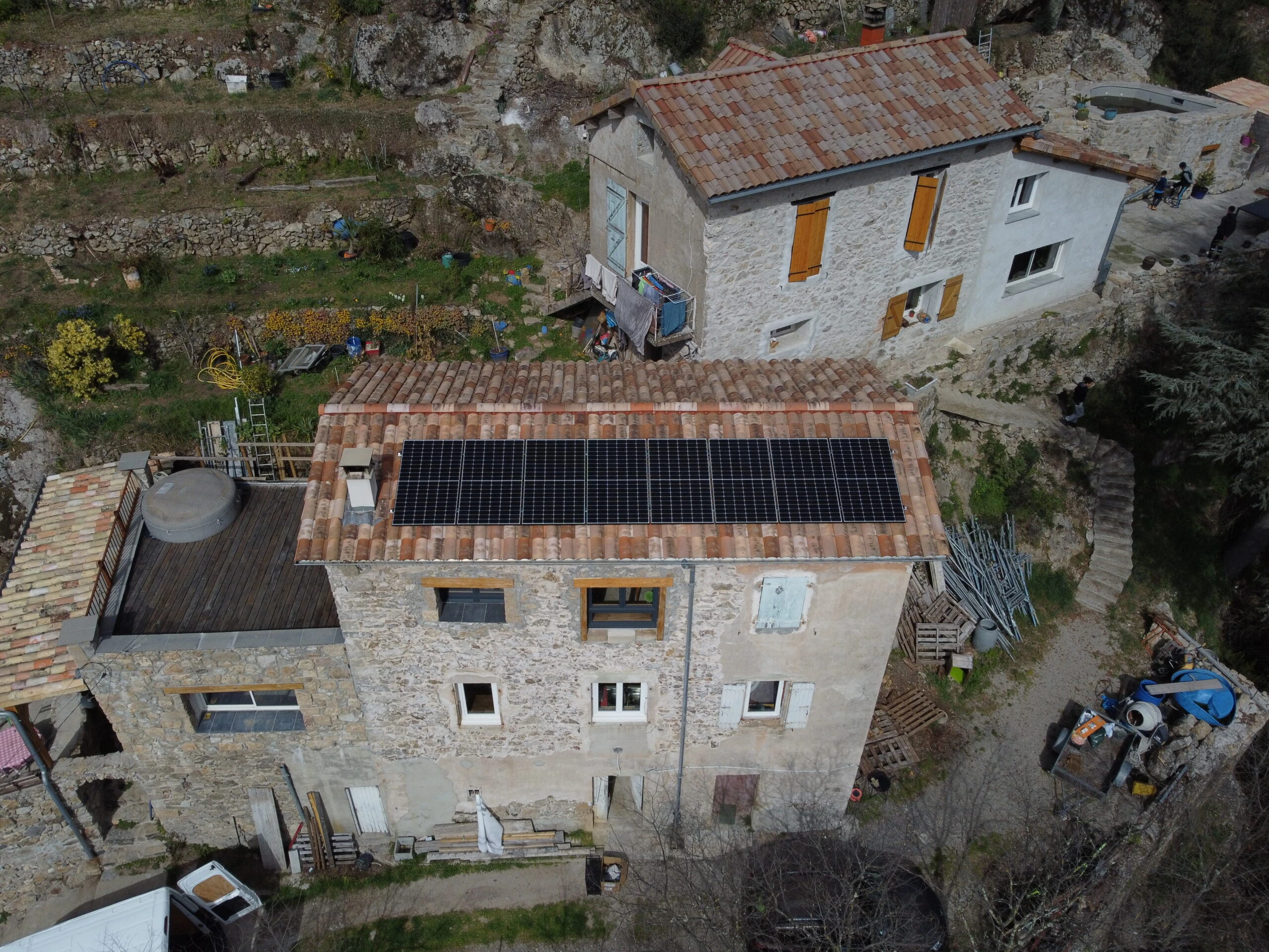 Maison de pierre équipée de panneaux solaires dans un village