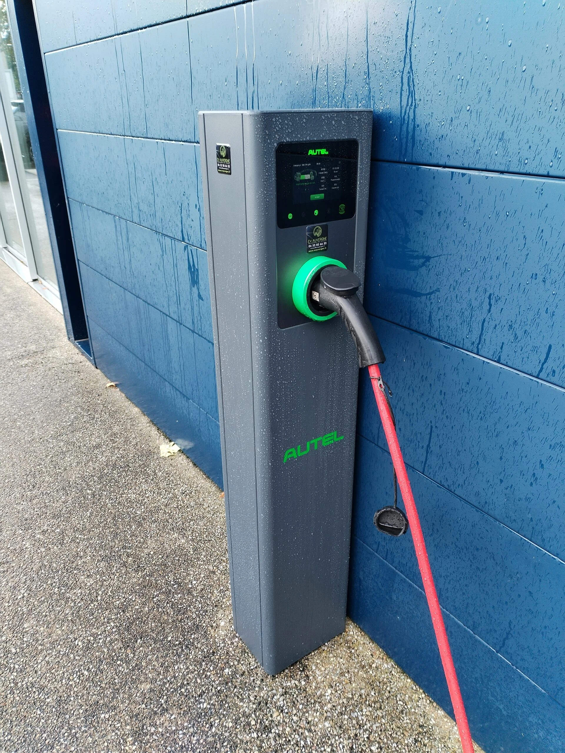 Point de charge sur pied installé contre un mur bleu