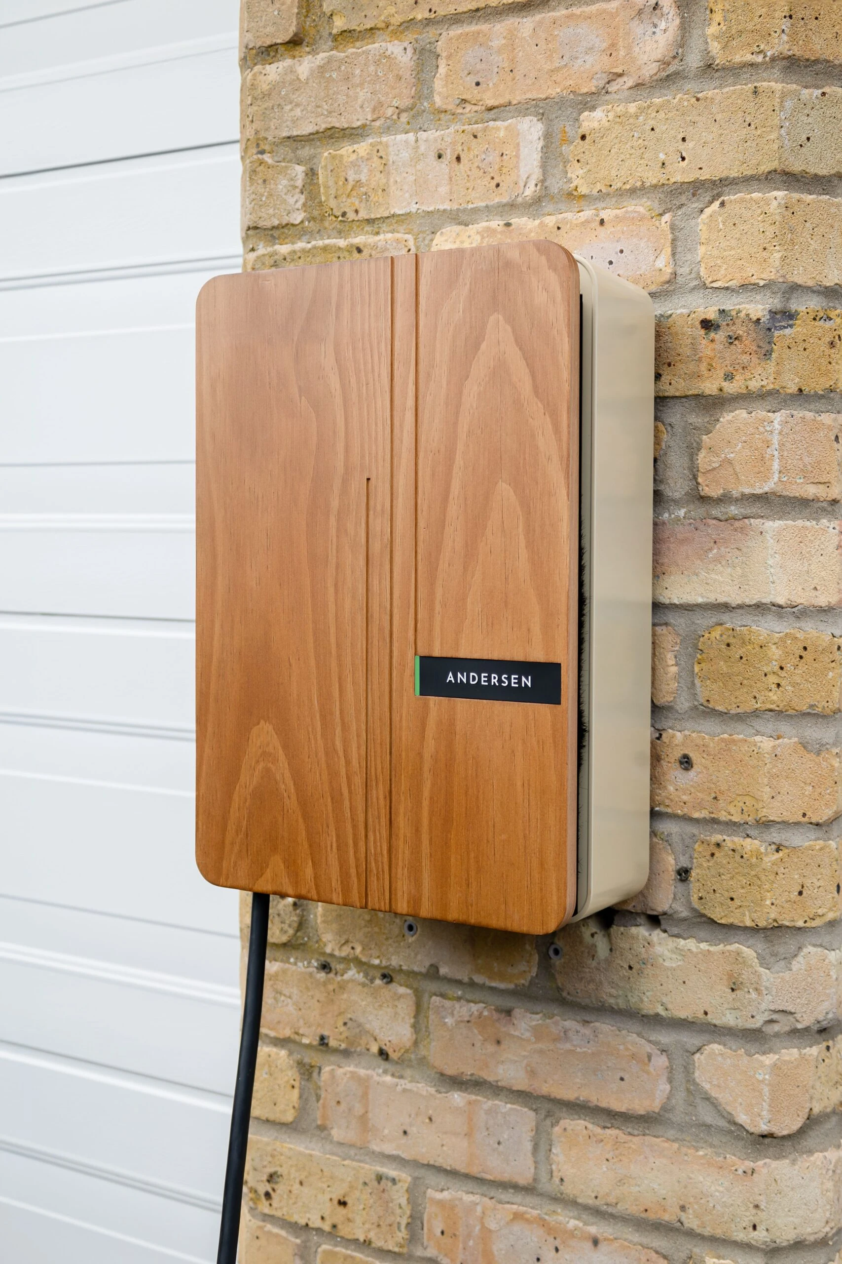 Borne de recharge habillée de bois fixée sur un mur en briques