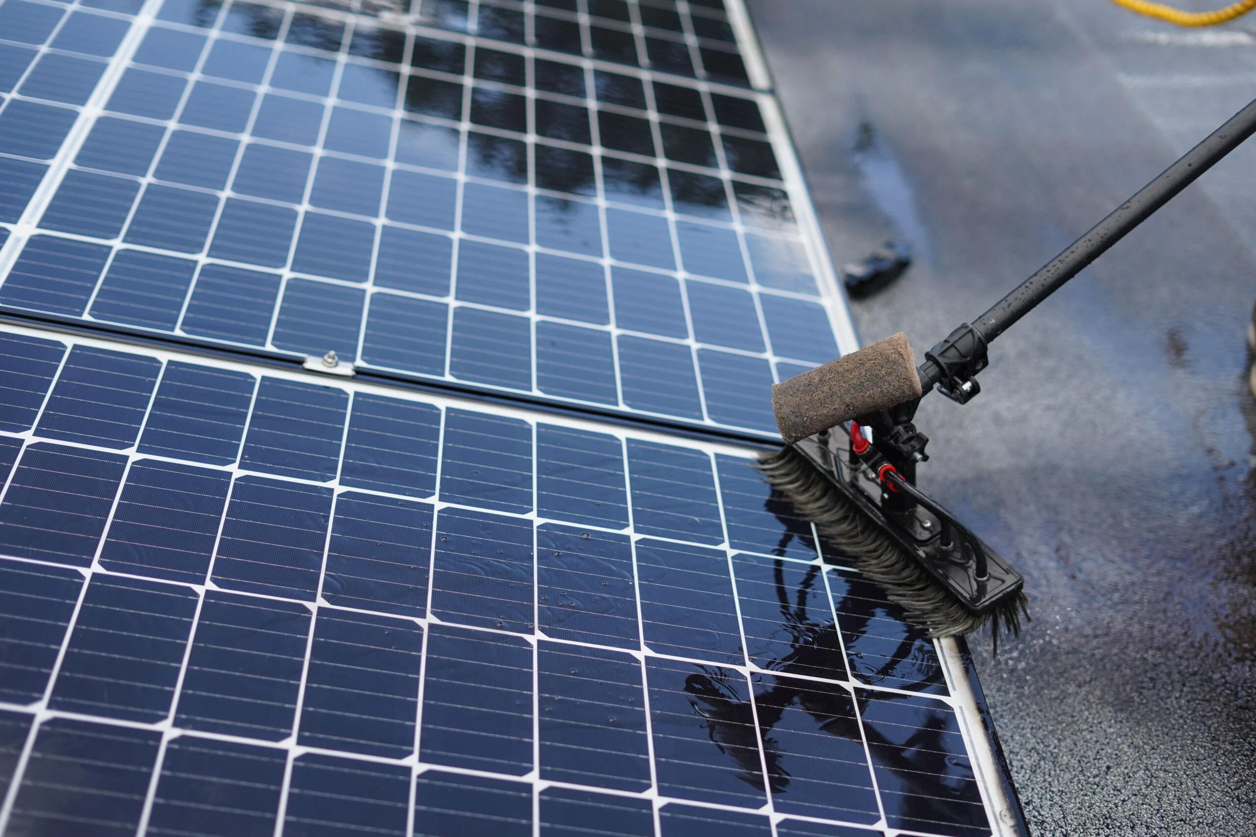 Brosse de lavage passée sur des panneaux solaires mouillés