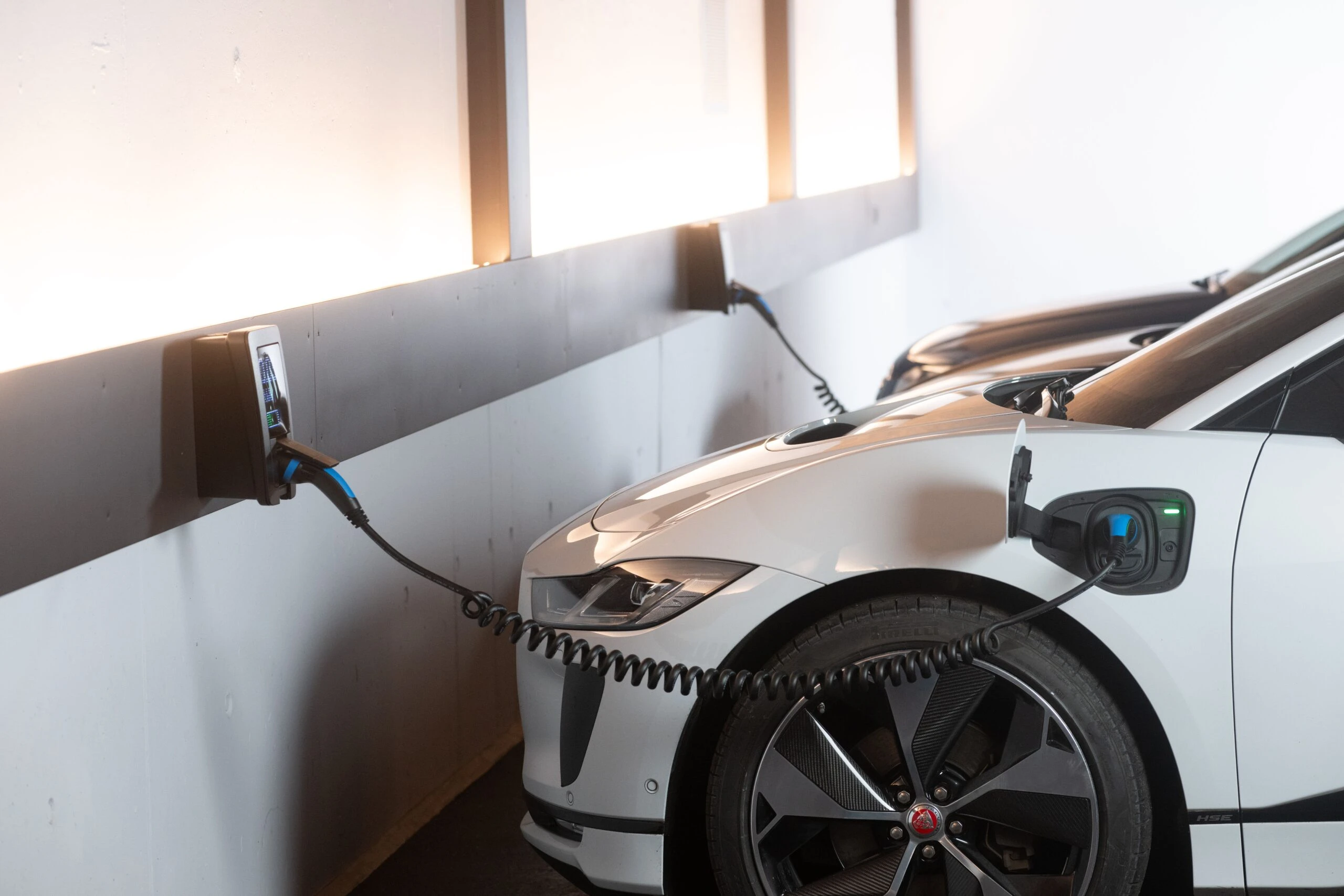 Voiture électrique blanche en charge dans un garage
